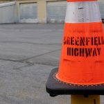 orange traffic cone labelled Greenfield Highway
