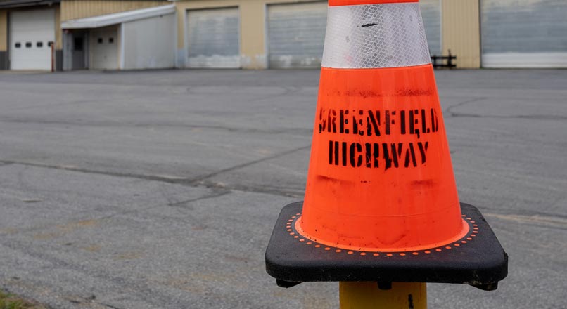 orange traffic cone labelled Greenfield Highway